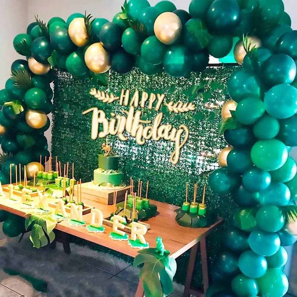 Festa de aniversário precisa de balões para festa na selva, arco de balões verdes, decoração e folhas de palmeira tropic