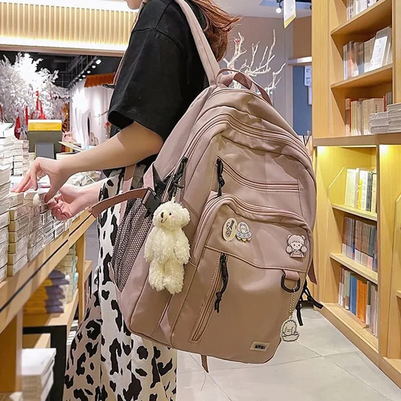 Mochila universitária, com grande capacidade interna, de uso escolar, viagens, passeios impermeável, acompanha chaveiro de ursinho e pingentes