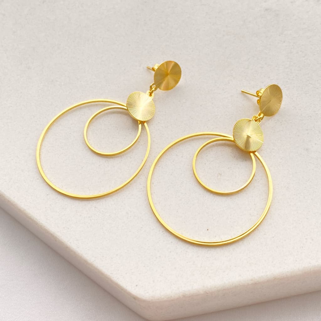 Brinco base redonda trabalhada dupla com pingente de duas argolas folheado a ouro 18k