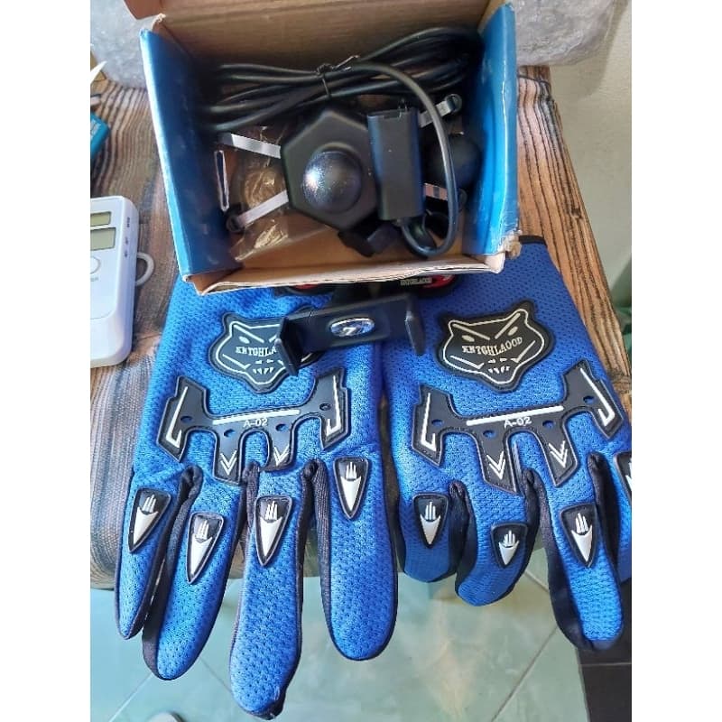 um suporte para de celular moto  um par de luva  e um suporte  de carro para celular