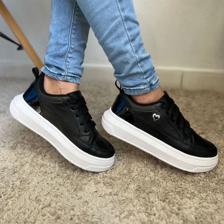 Elegância e estilo em um só calçado. Este flatform preto se destaca pelo detalhe em coração metálico, que traz modernida