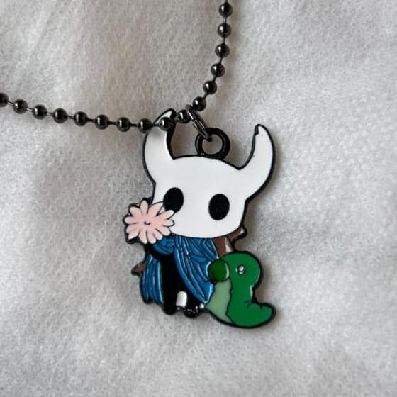Colar Game Hollow Knight com o Cavaleiro segurando uma flor e o verme Grub