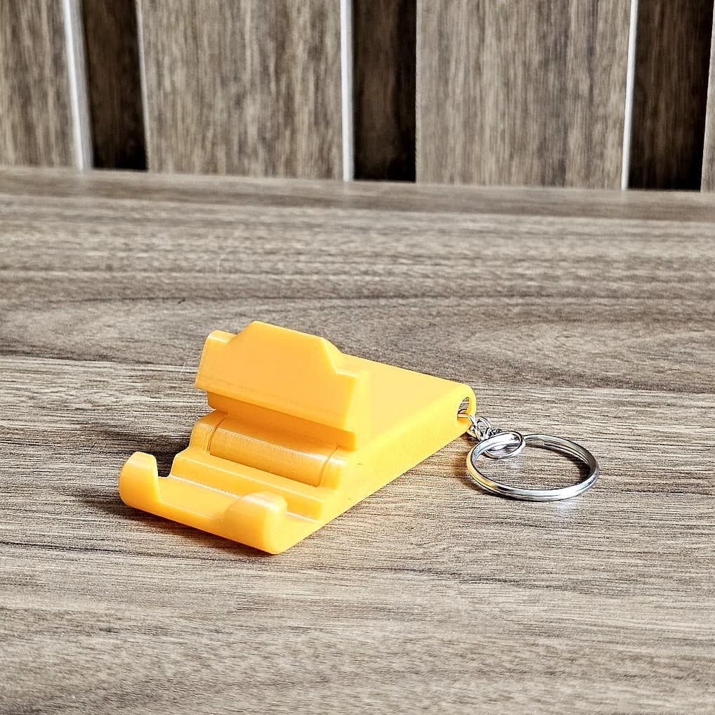 Chaveiro Suporte para Celular Dobrável – Porta Celular Portátil de Mesa