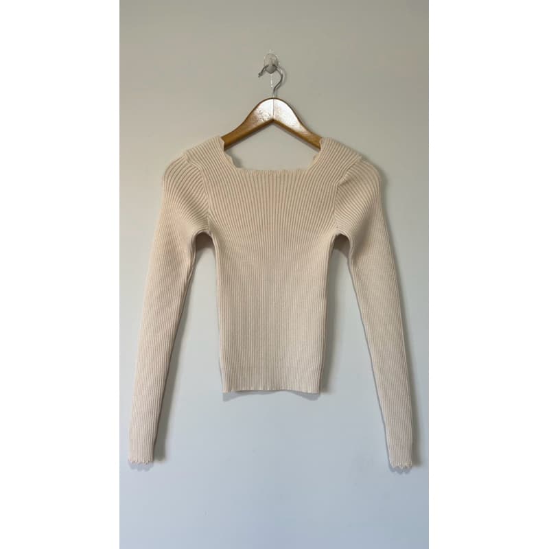 blusa de tricô canelada com detalhes no cós e manga longa.