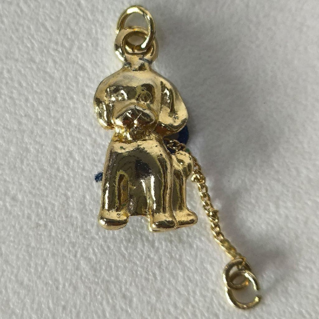 Pingente em metal dourado representando cachorrinho