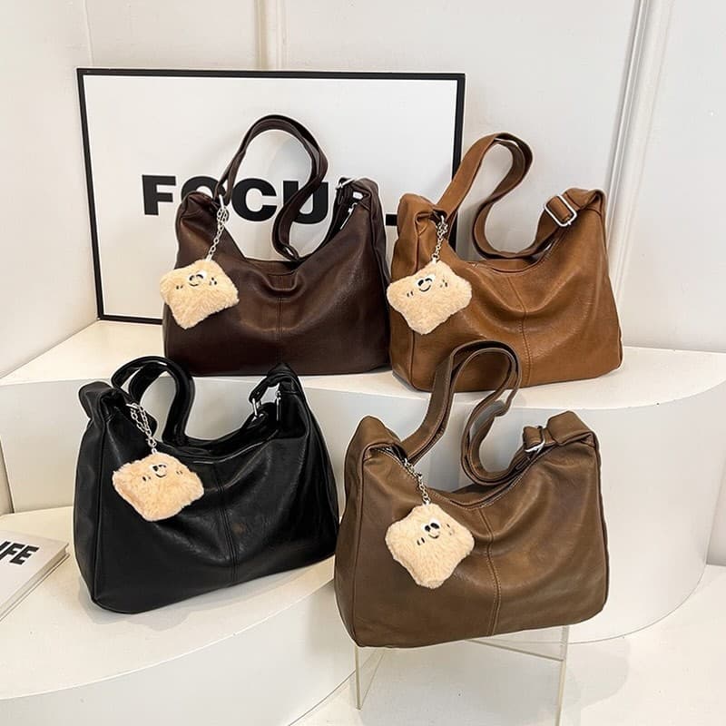 Bolsa feminina media com alça regulável e acompanha o chaveiro