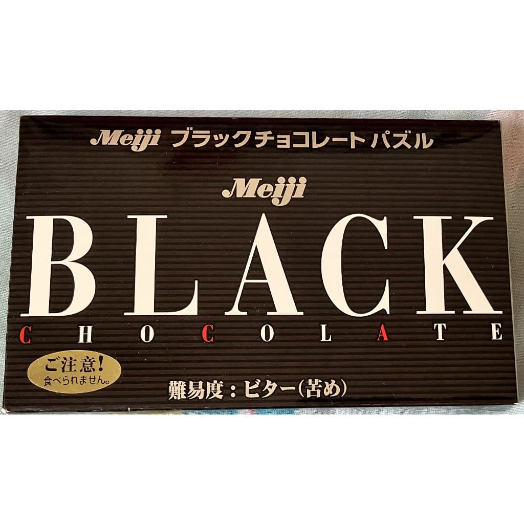 🍫 Quebra-Cabeça Chocolate Meiji Black – Puzzle Japonês (Não Comestível)