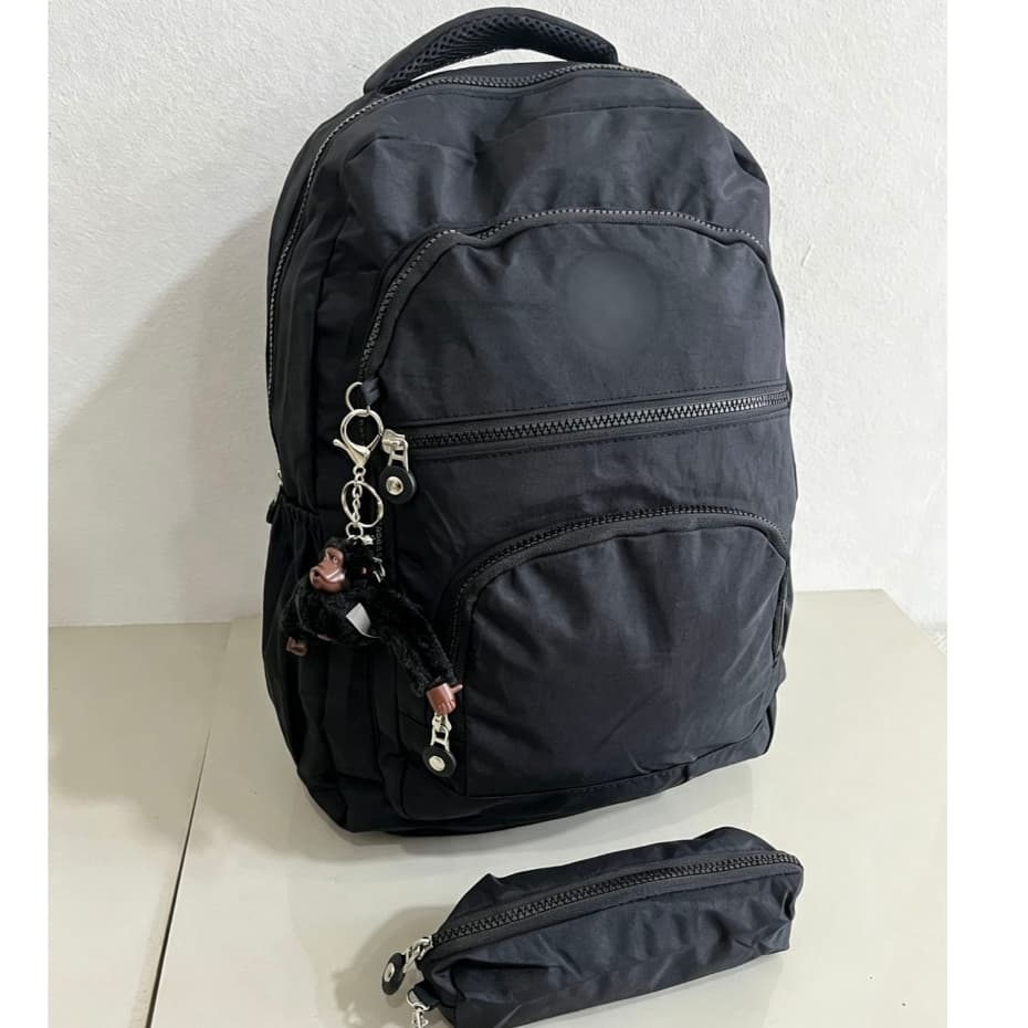 Esta mochila leve e unissex vem com uma pequena bolsa e um chaveiro de macaco.