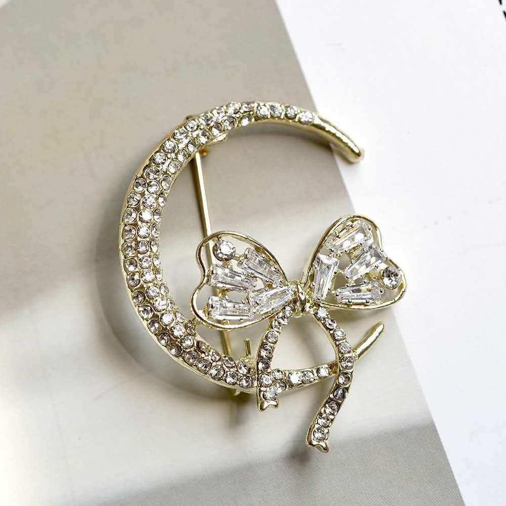 Broche feminino elegante e moderno com strass de cristal, laço e design de lua.