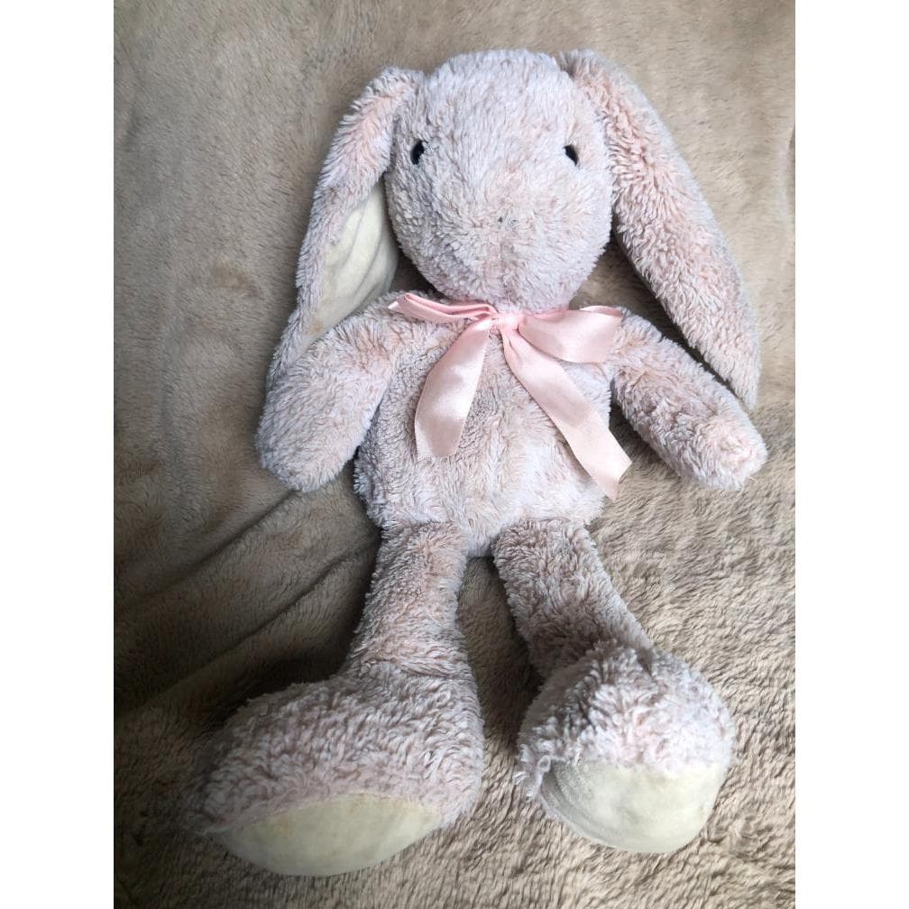 Coelho rosa de pelúcia com laço