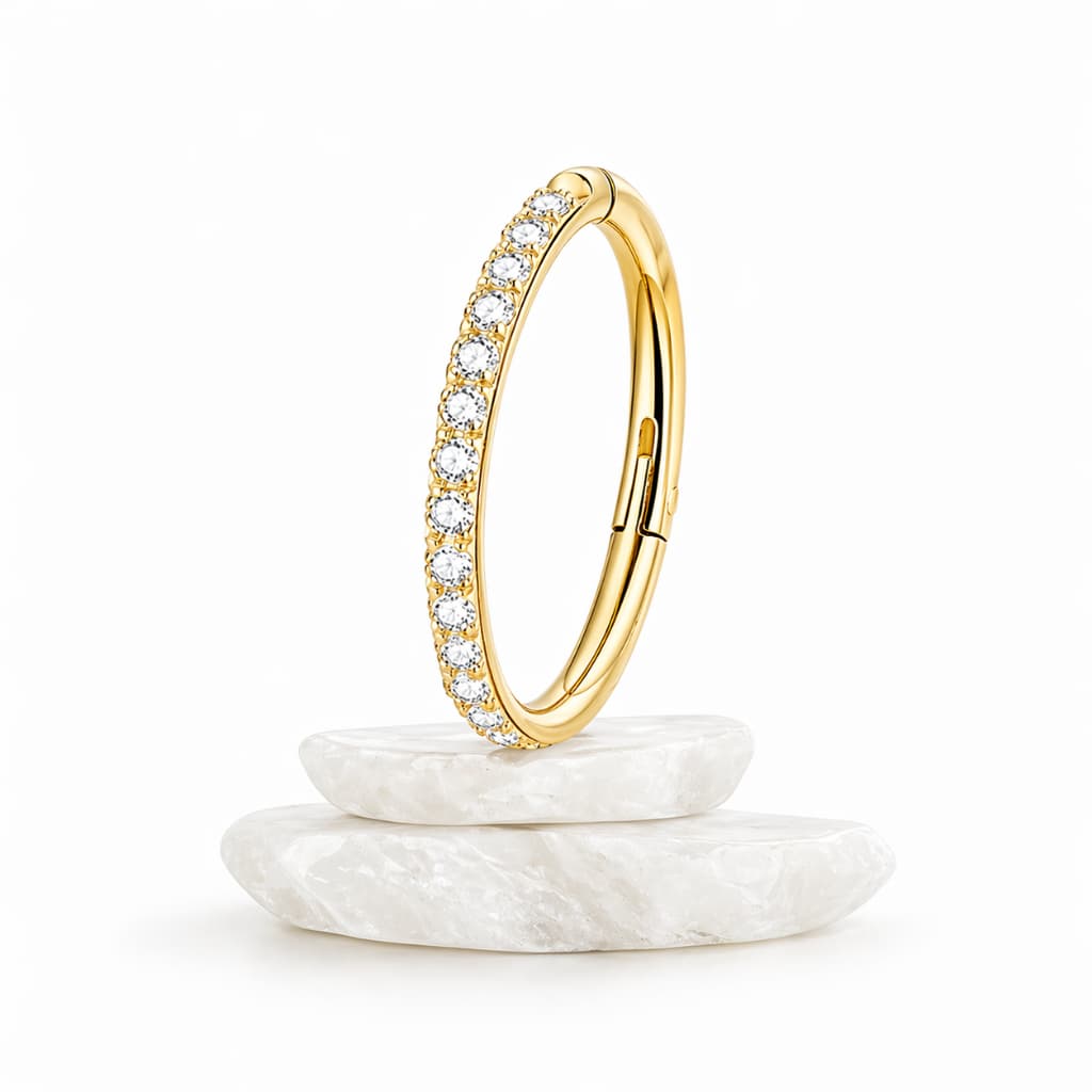 Piercing argola clicker em Titânio ASTM F136, cravejado com zircônias brilhantes e acabamento Premium Dourado