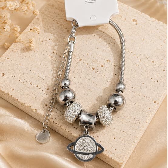 Pulseira Feminina Prateada 316L com Pingente Saturno e Pedras Brilhantes