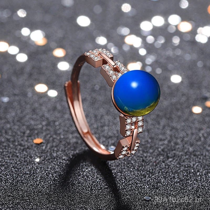 O mesmo modelo de anel de âmbar azul sintético de segunda geração, banhado a ouro rosado, da República Dominicana, exibi
