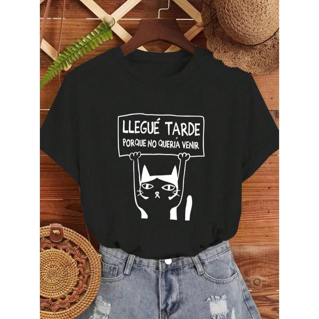 Camiseta feminina divertida com estampa de gatinho segurando placa "Llegué tarde porque no quería venir", perfeita para
