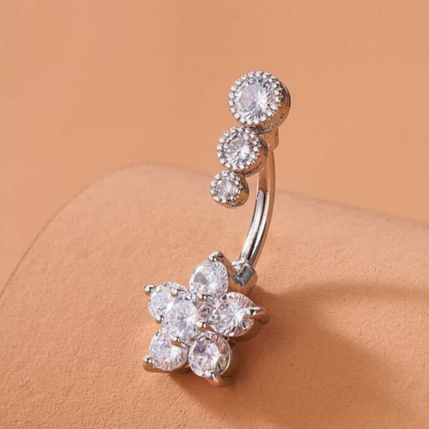 Piercing de umbigo em aço inoxidável, decorado com flores de ameixa e cravejado com zircônias cúbicas.
