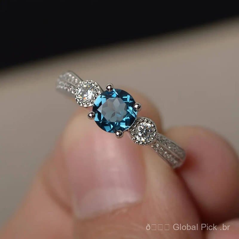 Anel fechado de ouro branco com zircônia azul, simples e elegante, design versátil.