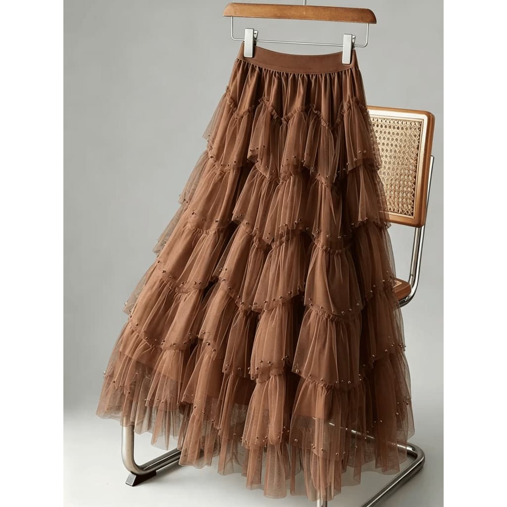 Saia midi evasê com tule irregular e aplicações de miçangas, cintura alta e modelagem ampla.  Casual    Em camadas