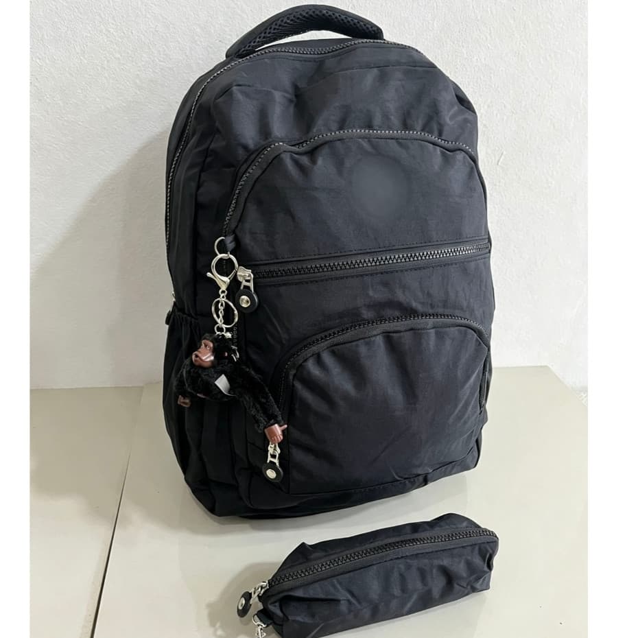 Esta mochila leve e unissex vem com uma pequena bolsa e um chaveiro de macaco.
