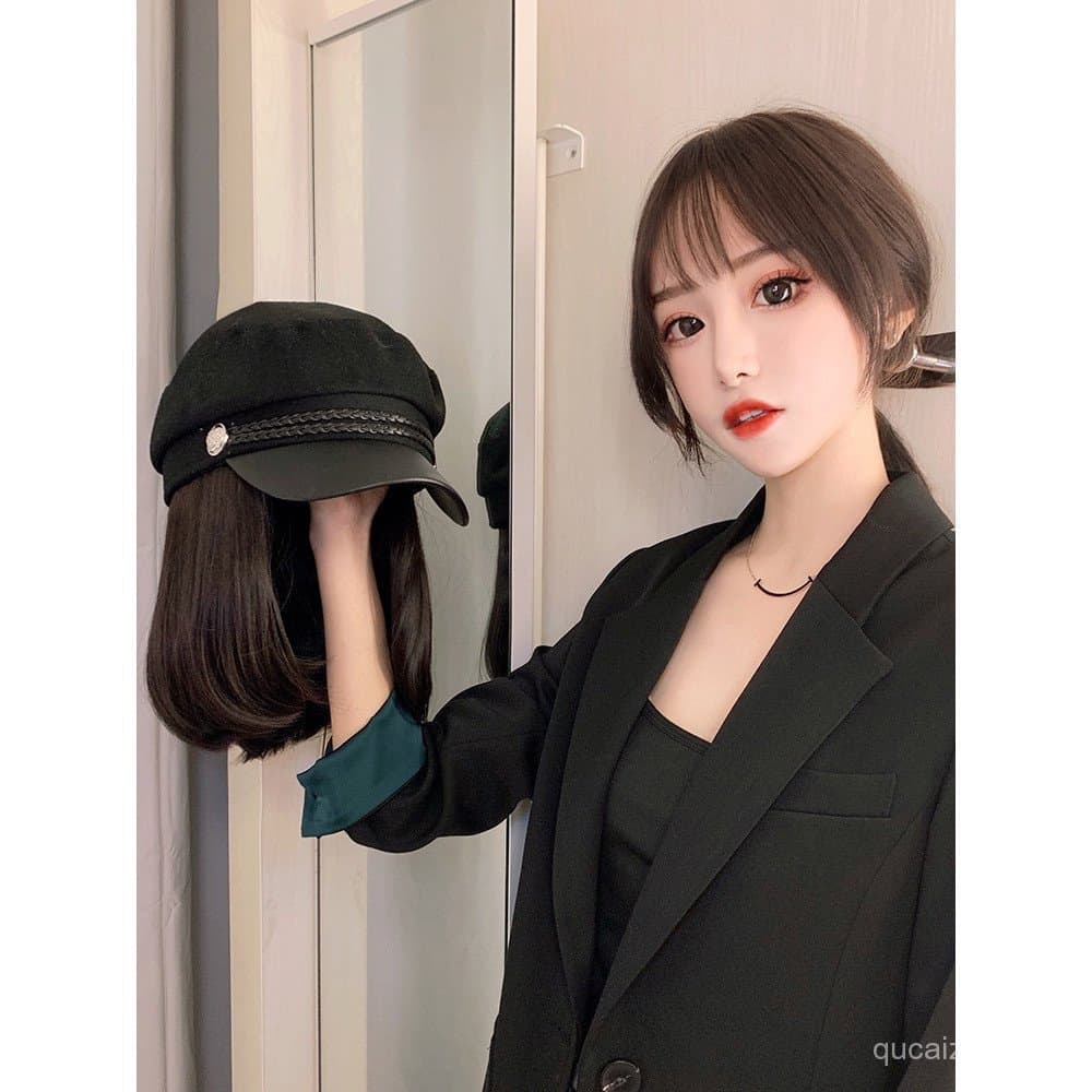 Peruca feminina de cabelo curto com boné azul marinho, penteado bob natural e estiloso.