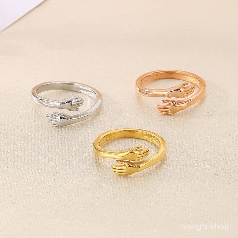 Anel personalizado de casal com design aberto para abraçar as mãos.