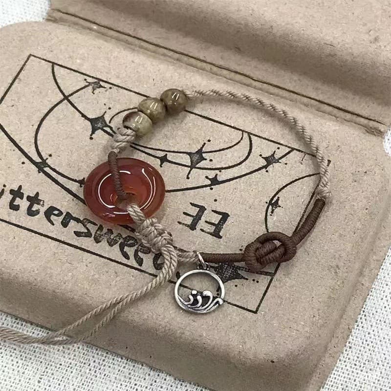 Pulseira circular vermelha, com motivos de pôr do sol e estilo étnico, modelo masculino, com um padrão entrelaçado que r