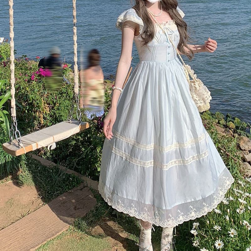 Vestido azul vintage francês em estilo fada, com mangas levemente onduladas, acabamento em renda e laço.