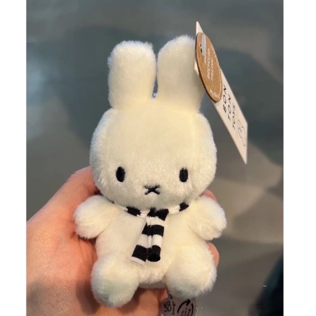 Encantadora boneca Miffy usando um cachecol listrado branco, um super fofo brinquedo de pelúcia de coelhinho branc