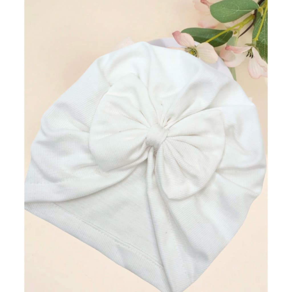 Um lindo gorro-cachecol de algodão para bebê com laço, disponível em diversas cores.