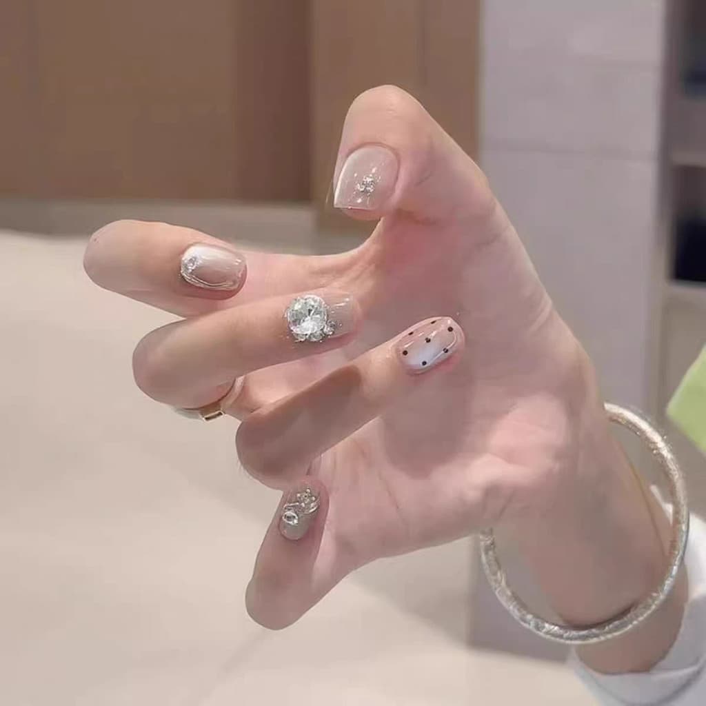 Unhas de verão estilo Hepburn com bolinhas brancas e brilhantes, com um toque sofisticado, efeito olho de gato suave e e