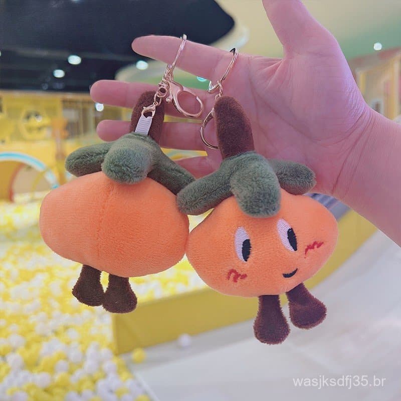 Chaveiro de pelúcia laranja fofo, com um pingente de boneco da sorte, adequado como presente de aniversário.