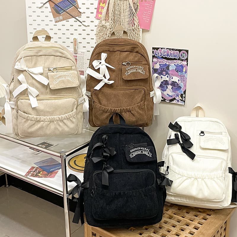 Mochila escolar estilo japonês para estudantes com laço de fita e design em veludo cotelê.