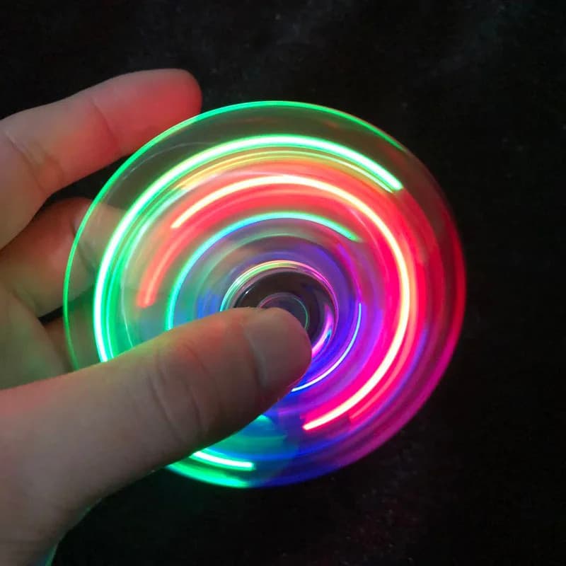 Fidget spinner transparente com luzes coloridas, usado para alívio do estresse e como presente para o Dia das Crianças.