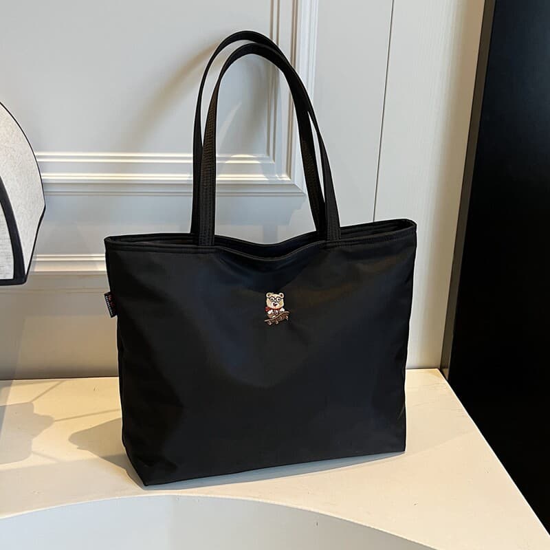 Bolsa de lona preta grande capacidade sacola feminina verão 2026 novo estilo bordado urso náilon ombro portátil saco de