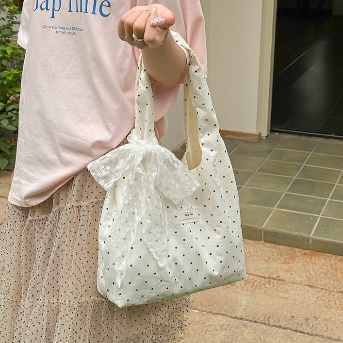 Bolsa tote suave e delicada, de cor branco-leitoso, acabamento fosco, baixa saturação, com detalhes de renda, etérea e e