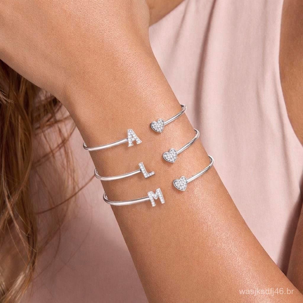Pulseira requintada com letras, apresentando um coração cravejado com zircônias. Banhada a prata 925 ou ouro 18k