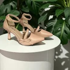 Sandália nude com salto alto fino e detalhe de laço