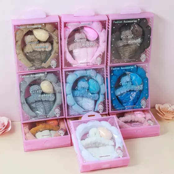 Conjunto de cinco peças em caixa, composto por presilhas de cabelo de pelúcia, faixa de cabelo de esponja, munhequeira p