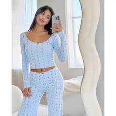 Conjunto de roupa de lazer de duas peças com estampa floral e laço, composto por camisa de manga longa e calça comprida.