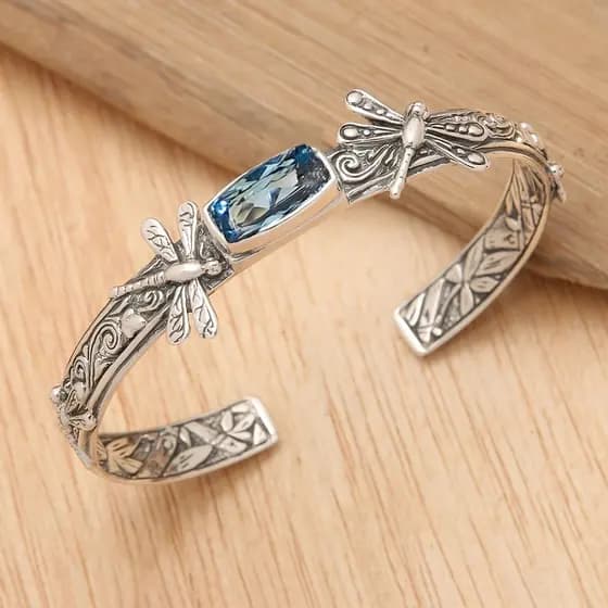 Uma pulseira aberta vintage com padrão de libélula em ambos os lados, incrustada com zircônia sintética azul marinho, ap