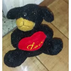 urso de pelúcia preto com uma focinheira marrom e um coração vermelho com a palavra Love bordada em amarelo