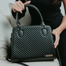 Bolsa Baú Santorini handbag com alça transversal, disponiveis em nove variações.