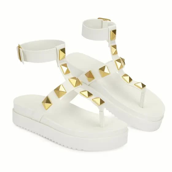 Sandália flat feminina branca com spikes dourados piramidais, ideal para looks urbanos e sofisticados
