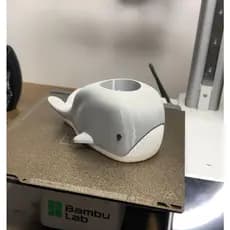 Porta lápis em formato de baleia com suporte para celular. Um item funcional e criativo para organização de mesas de est