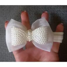 Tiara faixinha de bebê com laço em pérolas para batizado na cor branco.